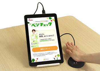 ベジチェック®」のセンサーに手のひらを当てる写真